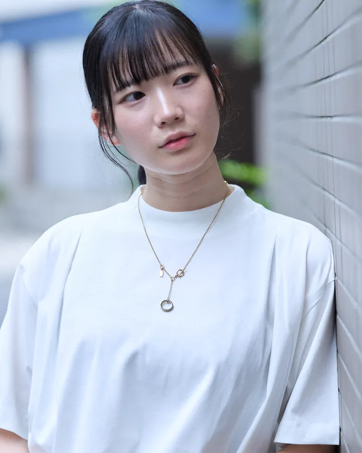 白いTシャツにシルバーのネックレスを着けた女性