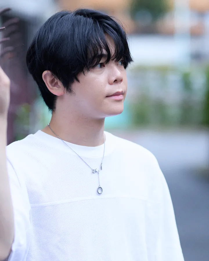 白いTシャツにシルバーのネックレスを着けた男性